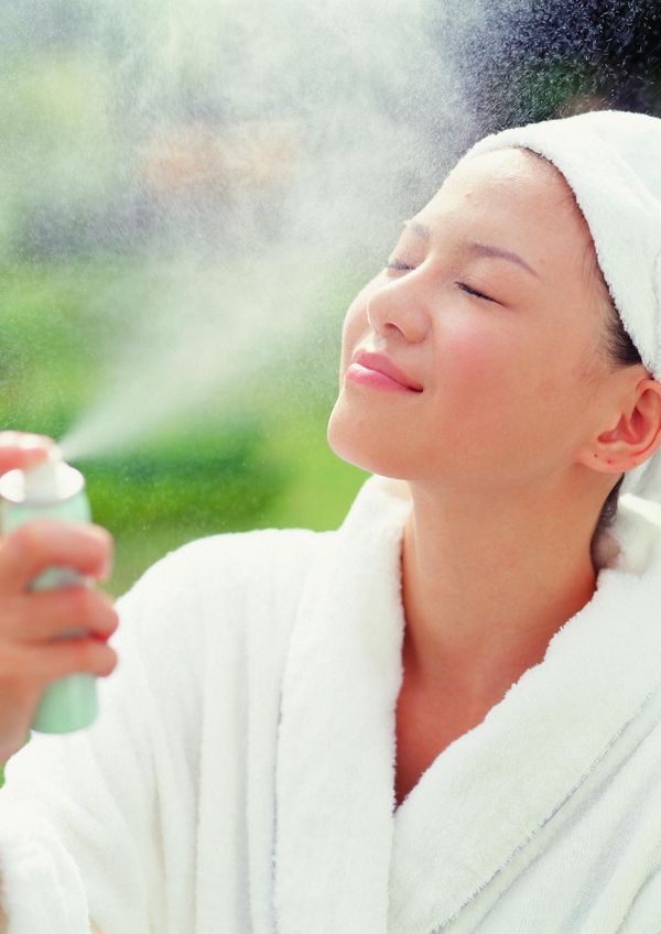 女性水疗图片-休闲保健图 拿喷雾剂 喷向脸上 